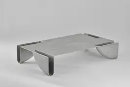 Aluminium table with four quarter wheel feet cut out from the table top 