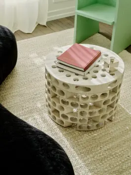 Perforated concrete coffee table on top of a wool and jute rug. 
