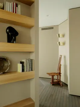 Hallway with expressionist inspired oblique walls and solid oak shelving for books and sculptures. 